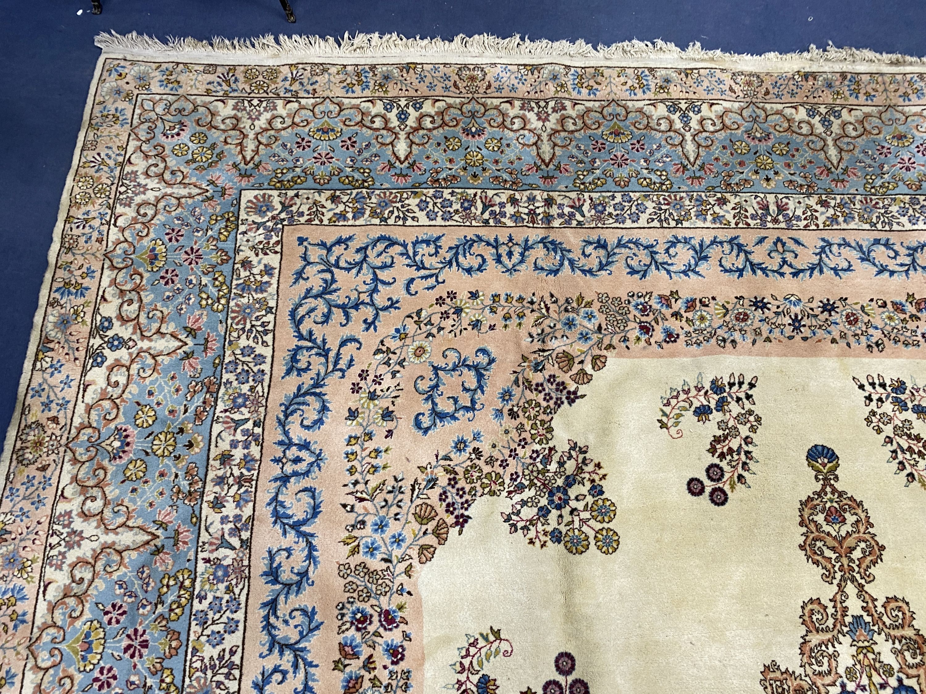 A large Kirman ivory ground carpet, 500 x 410cm